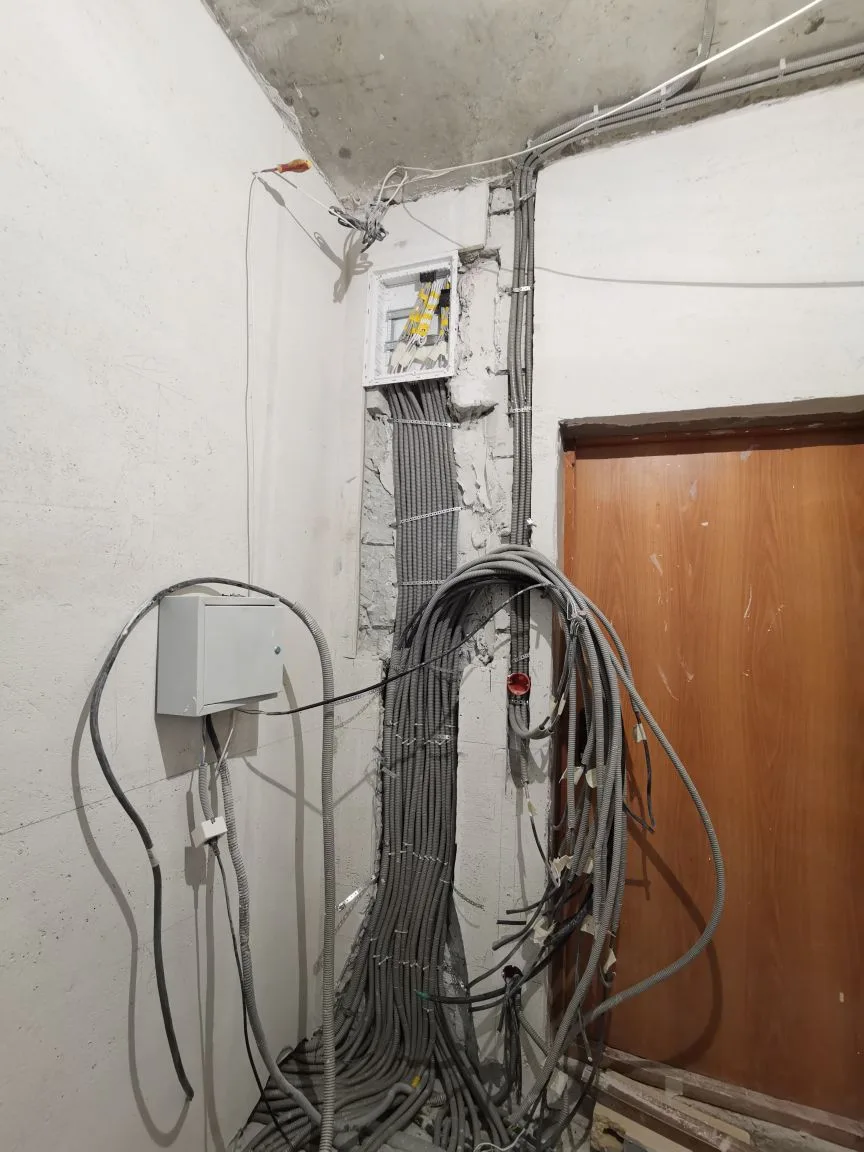 Подготовка ниши под силовой щит на 68 модулей: плотный вертикальный пучок гофротруб с кабелями для квартиры 145 м², сверху смонтирован слаботочный щит